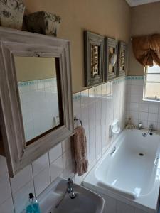 a bathroom with a tub and a sink and a mirror at Booiskraal Farm Stay Accommodation in Beaufort West