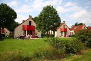 a group of people sitting at a table in front of a house at Gezellige vakantiewoning aan het water in Ewijk - recreational only no workers in Ewijk