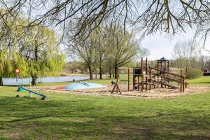 a playground in a park next to a lake at Gezellige vakantiewoning aan het water in Ewijk - recreational only no workers in Ewijk