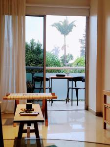 a living room with a table and a large window at Avenida Aconquija Suites in Yerba Buena