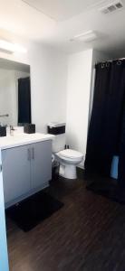 a bathroom with a white toilet and a sink at DTLA Luxury Condo with Pool, Gym, Work Pods & Conference Room in Los Angeles