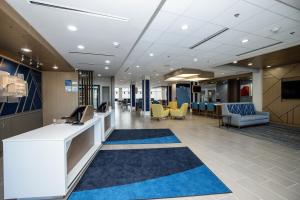 an office lobby with a reception desk and chairs at Holiday Inn Express & Suites Tampa Stadium - Airport Area, an IHG Hotel in Tampa