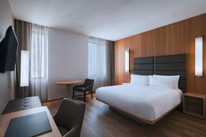 a bedroom with a bed and a desk and a chair at AC Hotel by Marriott Houston Downtown in Houston