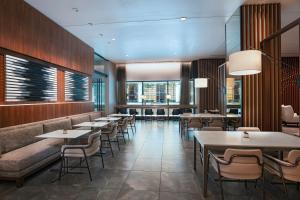 a restaurant with tables and chairs and windows at AC Hotel by Marriott Houston Downtown in Houston