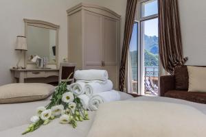una camera d'albergo con letto, asciugamani e scrivania di Hotel Riviera a Melide