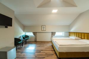 a bedroom with a large bed and a tv at HOTEL VITAL in Baile Felix