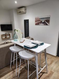 een witte tafel en stoelen in de woonkamer bij Au Doux Refuge 2 in Le Lambert