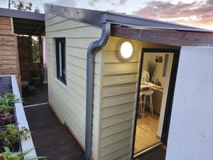 a tiny house with a large door on a deck at Au Doux Refuge 2 in Le Lambert