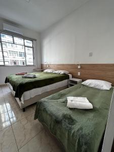 1 dormitorio con 2 camas y ventana grande en Studio 516 Copacabana Av Atlântica, Posto 6, en Río de Janeiro