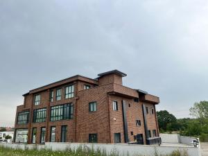 a red brick building with a fence in front of it at Serim Residence in Kocaeli