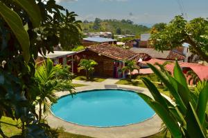 a large blue swimming pool in front of a village at Casa del Bosque in Trujillo