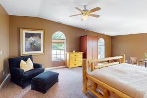 a bedroom with a bed and a chair and a ceiling fan at Scenic View Lodge - Entire Property in Bloomington