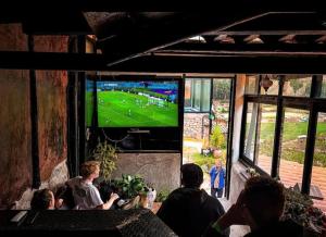 a group of people watching a soccer game on a television at Wolf Totem Studio Loft in Pisac