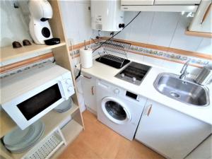 a small kitchen with a sink and a washing machine at Apartamento - Puerta del Sol in Madrid