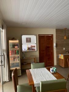 a dining room with a table and a refrigerator at Villa Peixe Na Telha in Porto De Galinhas