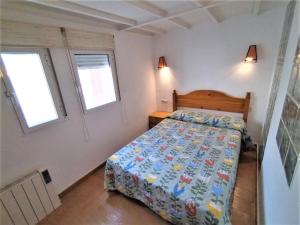 a small bedroom with a bed and two windows at Apartamento - Puerta del Sol in Madrid