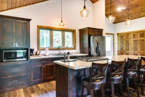 a kitchen with wooden cabinets and a large island with bar stools at Merrifield Vacation Rental with Dock and River Access in Merrifield