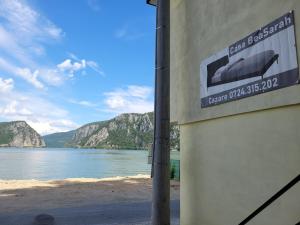znak na boku budynku w pobliżu zbiornika wodnego w obiekcie Casa BeaSarah. w mieście Dubova