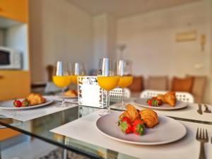 uma mesa com pratos de comida e copos de sumo de laranja em Confortable Apartamento en el Centro de Torremolinos con Parking em Torremolinos
