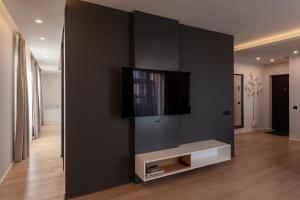 a living room with a flat screen tv on a wall at Sauna&Jacuzzi Apartment in Cluj-Napoca