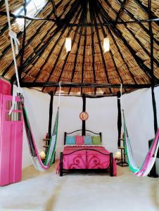a bedroom in a yurt with a bed and hammocks at Casa Maya - Alberca - Wifi Starlink - Tour Sostenibilidad in Izamal