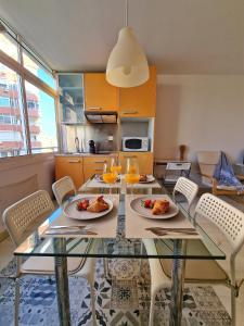 uma cozinha com uma mesa de jantar com pratos de comida em Confortable Apartamento en el Centro de Torremolinos con Parking em Torremolinos