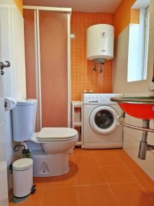 uma casa de banho com um WC e uma máquina de lavar roupa em Confortable Apartamento en el Centro de Torremolinos con Parking em Torremolinos