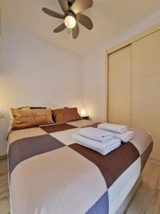 um quarto com uma cama grande e uma ventoinha de tecto em Confortable Apartamento en el Centro de Torremolinos con Parking em Torremolinos