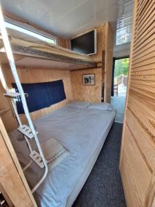 een slaapkamer met een bed in een tiny house bij Szalupa H9 in Zakroczym