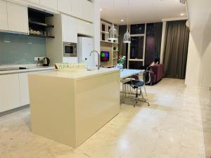 a kitchen and living room with a counter and a table at The Platinum Suites KLCC By World Luxury in Kuala Lumpur
