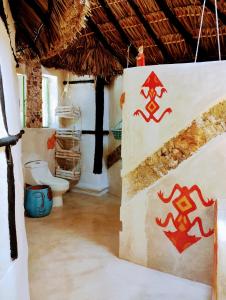 a bathroom with a toilet and a sign on the wall at Casa Maya - Alberca - Wifi Starlink - Tour Sostenibilidad in Izamal
