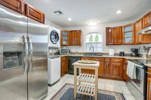 a kitchen with wooden cabinets and stainless steel refrigerator at New Orleans Duplex Walk to Parks and Restaurants! in New Orleans