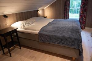 a bedroom with a bed and a nightstand next to a window at Furetoppen Panorama in Stryn
