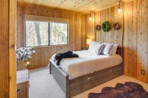 1 dormitorio con 1 cama en una habitación de madera en Rustic Big Bear Lake Cabin Retreat Near Skiing! en Big Bear Lake
