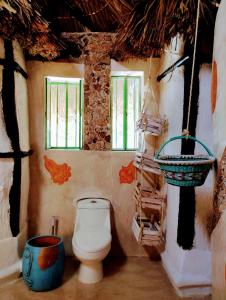 a bathroom with a toilet and a basket on the wall at Casa Maya - Alberca - Wifi Starlink - Tour Sostenibilidad in Izamal