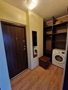 een kleine badkamer met een wasmachine en een deur bij Butas 34 in Šiauliai