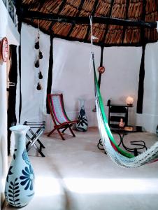 a hammock in a room with chairs and a table at Casa Maya - Alberca - Wifi Starlink - Tour Sostenibilidad in Izamal