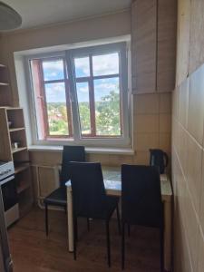 een keuken met een tafel en stoelen en een raam bij Butas 34 in Šiauliai