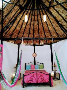a bedroom in a yurt with a bed and two hammocks at Casa Maya - Alberca - Wifi Starlink - Tour Sostenibilidad in Izamal