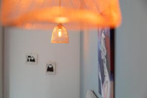 a light hanging over a room with a white wall at La Locanda d'Oro in Monastir