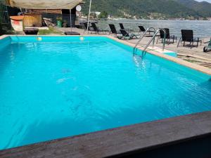 a large blue swimming pool next to a body of water at Casa BeaSarah. in Dubova