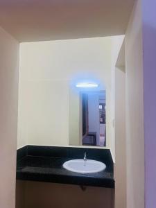 a bathroom with a sink and a mirror at Hotel Sunday - Townhouse Club Airport Trivandrum in Trivandrum
