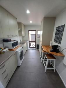 a kitchen with a sink and a table and a microwave at Palms on Bruntwood in Tamahere