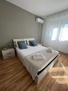 a bedroom with a large bed with two towels on it at Welcome Home Quartu Sant'Elena in Quartu SantʼElena