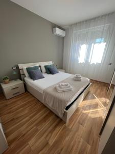 a bedroom with a large bed and a wooden floor at Welcome Home Quartu Sant'Elena in Quartu SantʼElena