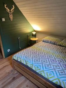 een slaapkamer met een bed en een groene muur bij Domki że Hej Bieszczady in Ustrzyki Dolne