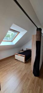 a attic room with a bed and a window at Chez Julie in Arnage