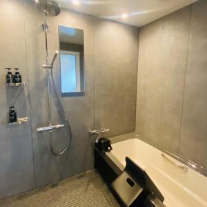 bagno con doccia, vasca e lavandino di The Box House a Furano