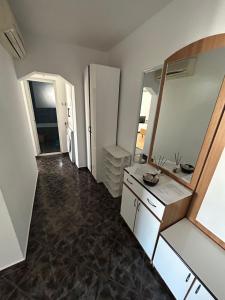 a bathroom with a vanity and a large mirror at SJ Apartment in Tulcea