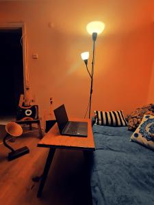 Cette chambre comprend un lit et un ordinateur portable sur une table. dans l'établissement ZULA HOUSE, à Izmir